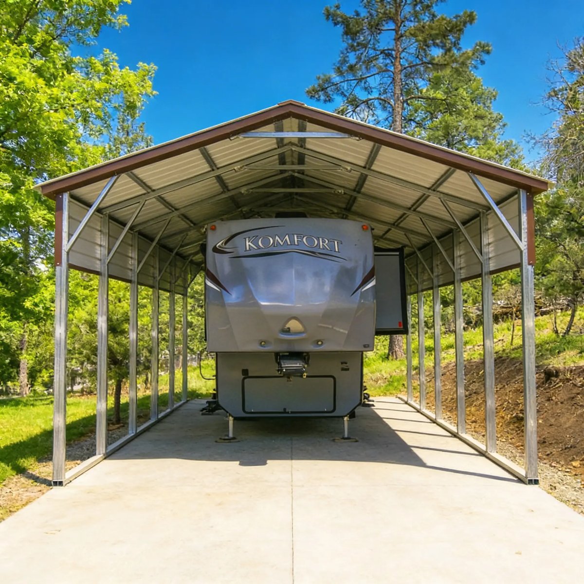 Open metal RV cover with a vertical roof sheltering a fifth-wheel camper on a concrete pad